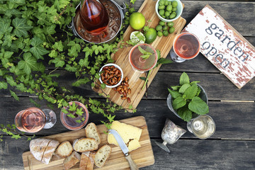 Overhead view of food with wine and plants on wooden table