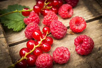 Berries of currants and raspberries on an old board. Red berries on an old board.