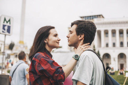 Side view of young couple looking each other face to face in city