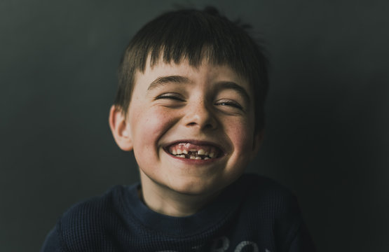 Cheerful Boy Standing Against Wall