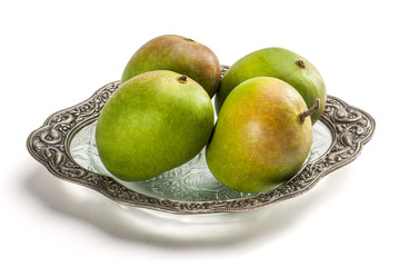mangoes on glass plate isolated on white background