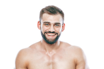 Fototapeta premium He stroked and touched his beard. A beautiful beard. Beautiful sporty guy male power. Fitness muscled in blue shorts. on isolated white background.