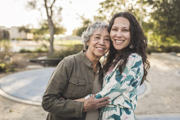 Happy mother and daughter embracing outdoors