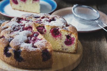 Cherry cake and slice of cake on rustic table