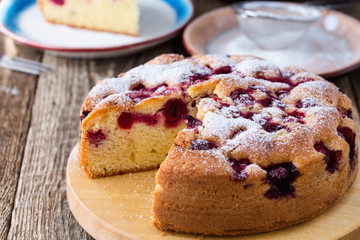 Cherry cake and slice of cake on rustic table