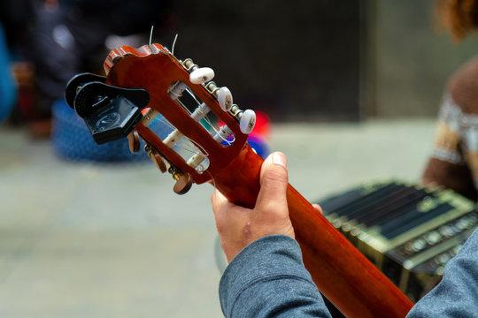 Close-up of neck of guitar with bandoneon in the background