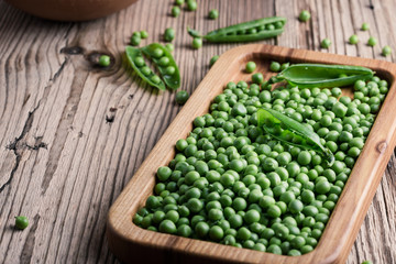 Fresh organic green peas on rustic wooden table, harvest time