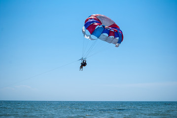 Fototapeta na wymiar parasailing on a parachute fly two people