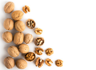 Walnut in shell and peeled scattered on a white. The view from the top.