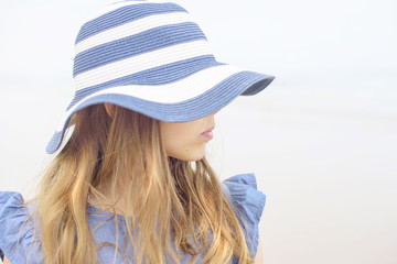 girl in a hat near the ocean