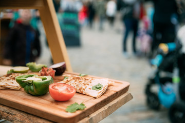 Tasty Pancakes And Vegetables Lie On The Wooden Board At A Festival