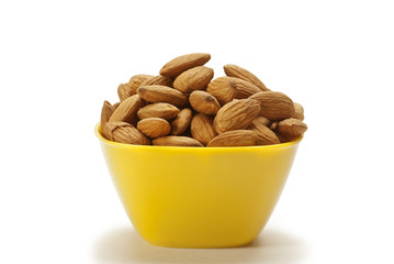 Almonds in yellow bowl isolated on white background