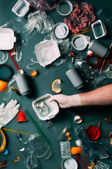 partial view of man in latex glove cleaning water from trash, ecology protection concept