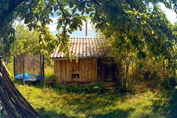 Wooden bath and trampoline on a sunny summer day. Elements of the village.