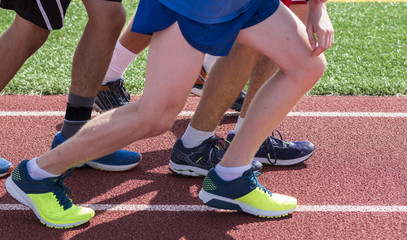 Legs and shoes starting a race on a track