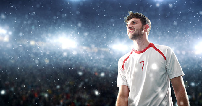 Soccer player celebrates a victory on the professional stadium while it’s snowing.