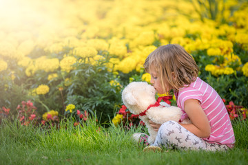 Adorable girl kissing her favourite teddy bear