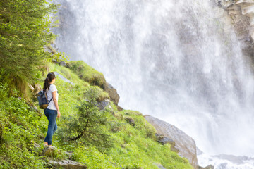 Naklejka premium Adventurous girl discovering a huge waterfall in the woods