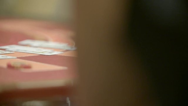 Slow motion shot of cards and chips on velvet poker table in casino. Gambling, luck and addiction concept.