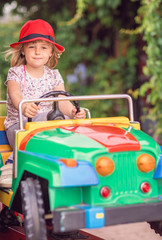 Little girl driving a toy car