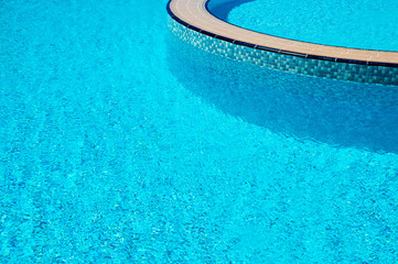 Background of water surface in blue swimming pool with the edge