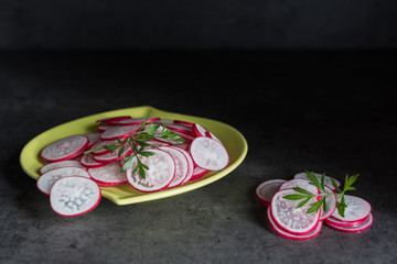 Fototapeta na wymiar Sliced radishes on a green dish