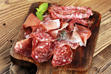 Food tray with delicious salami, raw ham and italian crudo or jamon. Meat platter with selection