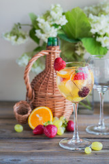 Homemade refreshing fruit sangria or punch with champagne, strawberries, oranges and grapes.