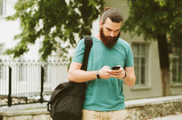 man with beard using phone outdoor