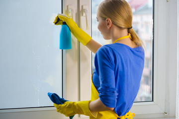 Woman cleaning window at home