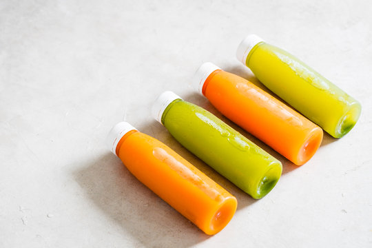 Row Of Plastic Bottles Of Cold-pressed Unprocessed Fruit And Vegetable Juices, From Above, Light Gray Table. Body Cleance, Fast Concept. Minimalism Food Photography. Copyspace