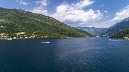 Aerial beautiful view from above to Kotor Bay and regular passenger ferry from Lepetane to Kamenari by a sunny afternoon