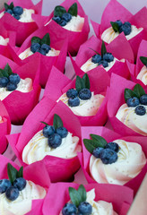 Delicious dessert blueberry capcasks with fresh berries and whipped cream. Wedding baking. Vertical photo.