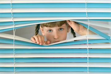 looks through the blinds