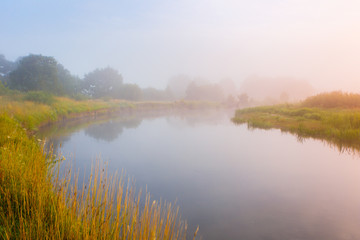 Fototapeta na wymiar Foggy morning over local river in Belarus