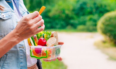Young woman eating from lunch box outdoor © lithiumphoto