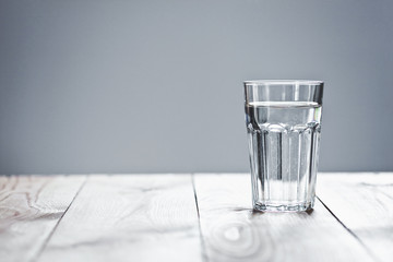 Glass of pure water on neutral background with copy space