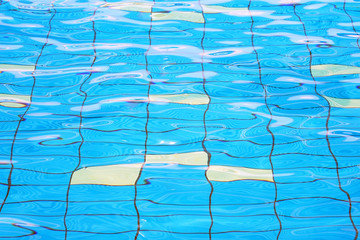Pure blue water in the pool. Water background. Swimming pool bottom caustics ripple and flow with...
