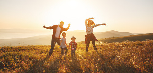 Happy family: mother, father, children son and daughter on sunset