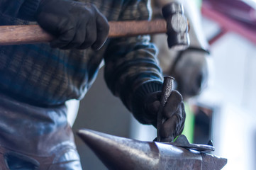 Blacksmith shaping the horse shoes