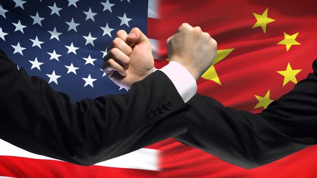 US vs China confrontation, countries disagreement, fists on flag background