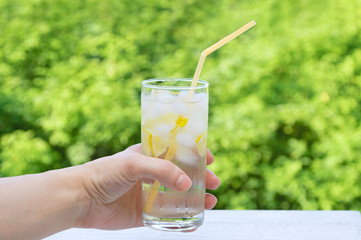 A glass with a chilled cocktail in his hand. Close-up.