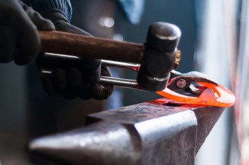 Blacksmith shaping the burning horse shoes
