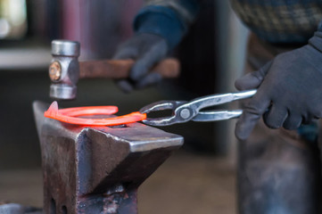 Blacksmith shaping the burning horse shoes