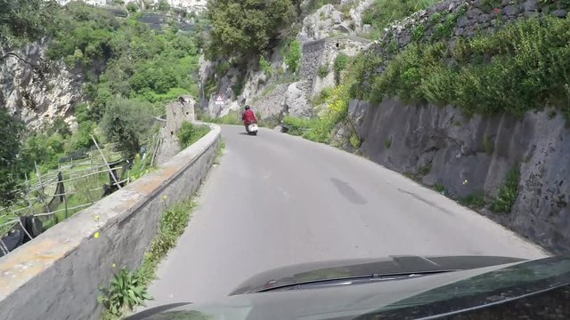 Footage taken from car roof of Italian roads located at Amalfi Coast Italy following typical Italian scooter driving over the narrow one way street corners warp stabilized view 4k high resolution