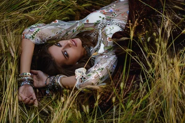 Afwasbaar Fotobehang Gypsy meisje dat in het gras ligt