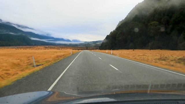 driving on road in knobflat to milford sound fiordland national park new zealand