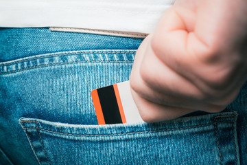 Male Hand Grabbing A Bank Card In The Back Pocket Of A Jeans Trouser
