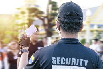 Obraz premium Male security guard using portable radio outdoors.