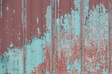Grungy red metal painted sheet peeling paint